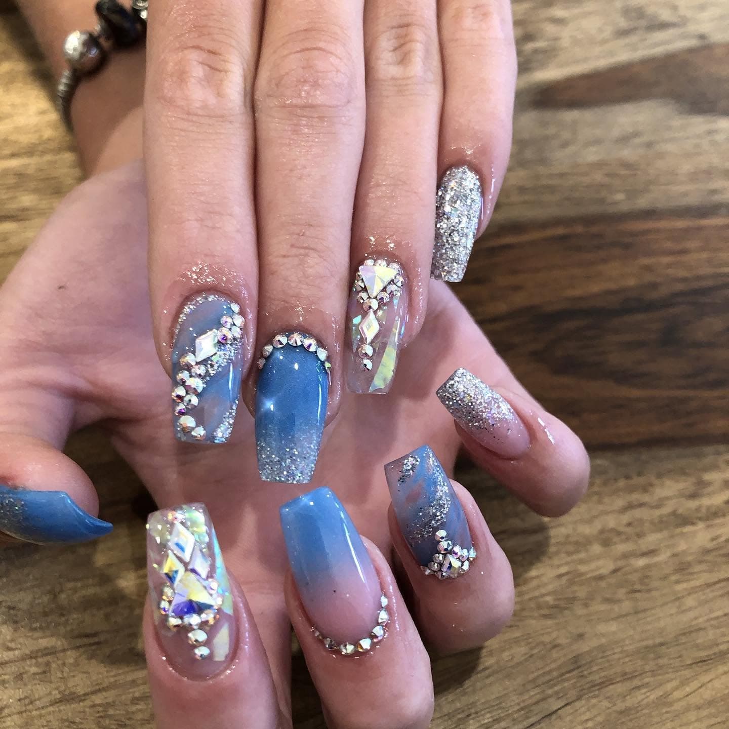 Blue marble nails with silver glitter and rhinestone accents